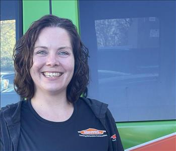 Wendy Lavery, Office Manager, standing in front a SERVPRO vehicle.